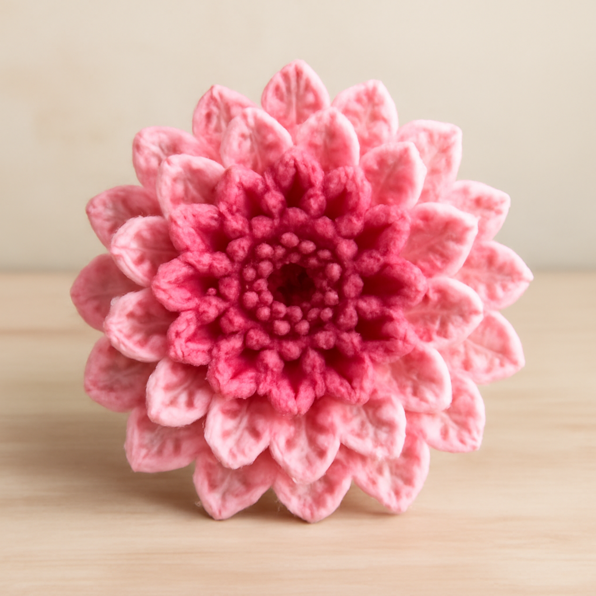 Beautiful crochet dahlia flowers in light pink, dark pink, and cream with layered petals, approximately 6-8 inches diameter.